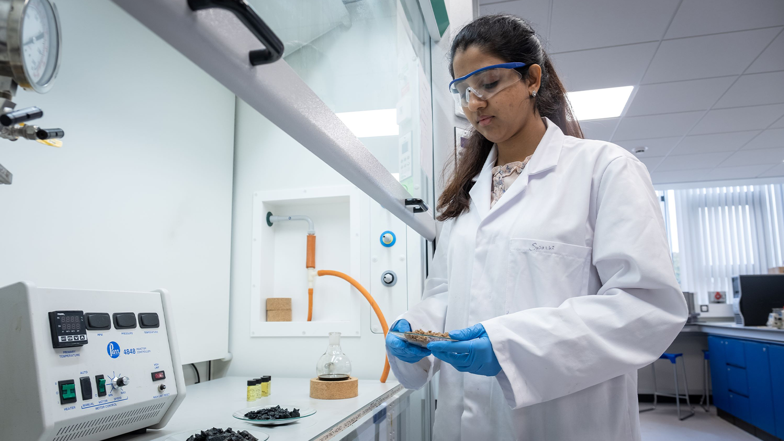 UKRI Interdisciplinary Centre for Circular Chemical Economy team member wearing goggles and lab coat holding lab equipment